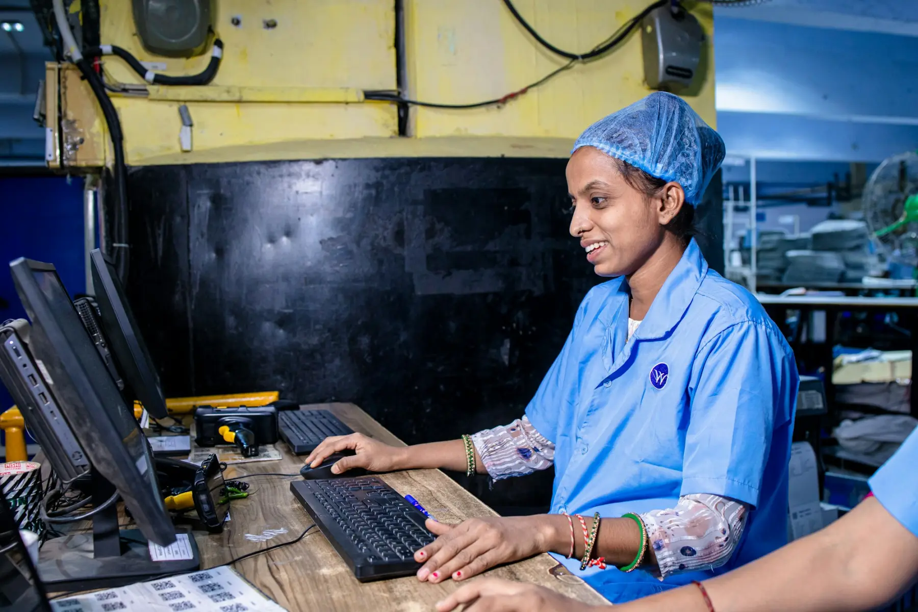 A technician working at a computer on a factory floor